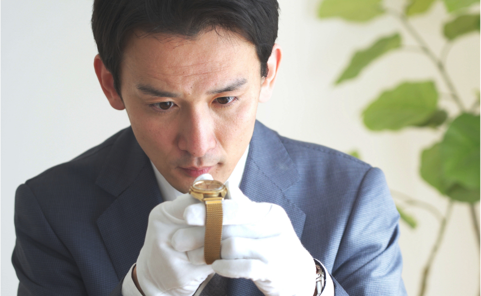 古い時計を鑑定するスーツ姿の男性