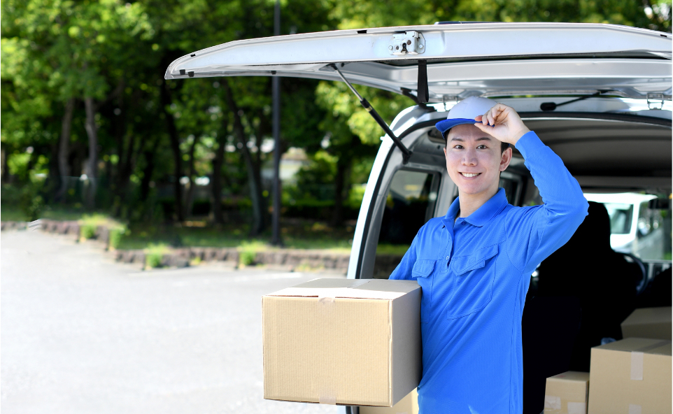 段ボールを車に運ぶ作業スタッフ